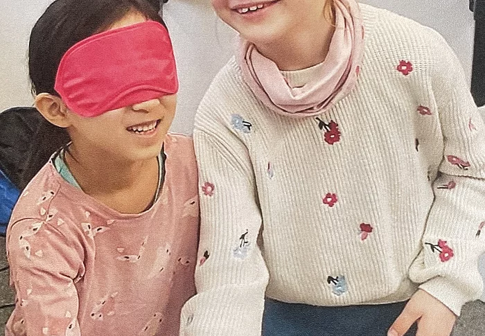 zwei Kinder mit Augenbiden ertasten ein Kustobjekt