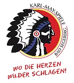 Logo der Karl-May-Spiele Bad Segeberg mit stilisiertem Indianerprofil vor rotem Kreis und dem Schriftzug 'WO DIE HERZEN WILDER SCHLAGEN!'