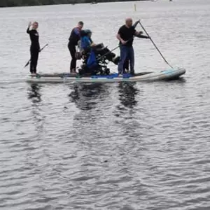 Rollstuhlfahrer mit vier Begleitpersonen auf einem StandupPaddelboard