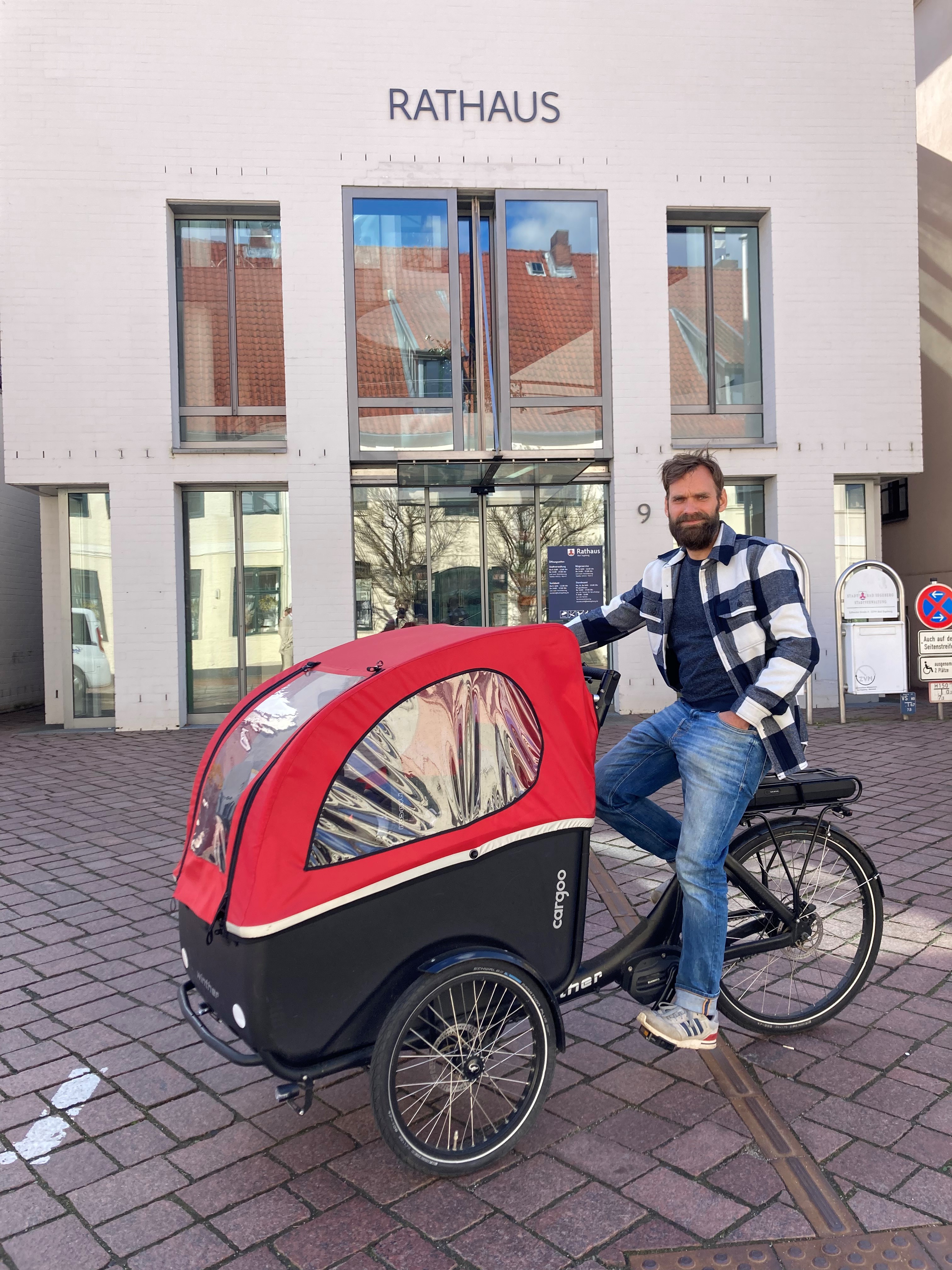 Bild vergrößern: Der neue ehrenamtliche Radverkehrsbeauftragte (Lasse Mester-Sundgaard) auf einem Lastenfahrrad vor dem Rathaus
